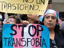 Miembros de grupos LGBTQ+ protestan frente al Ministerio de Salud contra un nuevo decreto gubernamental que cataloga el transexualismo como “trastorno mental” en Lima, el 17 de mayo de 2024, durante el Día Internacional contra la Homofobia, la Transfobia y la Bifobia. © Cris BOURONCLE / AFP